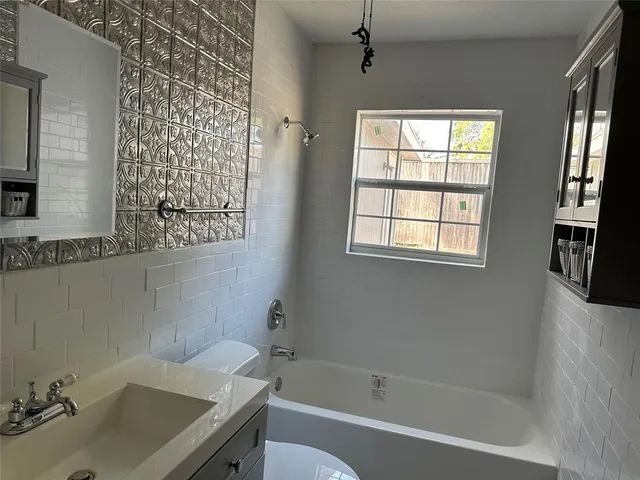 a bath room with a sink and a bath tub