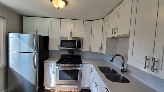 a kitchen with stainless steel appliances a refrigerator a sink a stove and cabinets