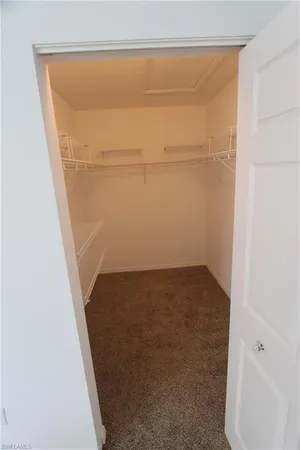 a bathroom with a granite countertop sink a toilet a mirror and a window