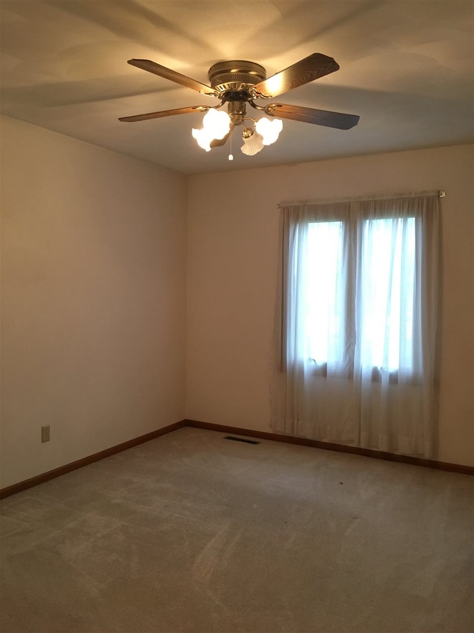 6620 North Point Road, Unit 2 Rockford, IL 61108 - Photo 4 of 21 an empty room with a chandelier fan and windows