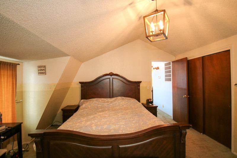 8053 South Rio Avenue Reedley, CA 93654 - Photo 21 of 30 a bedroom with a bed and a chandelier