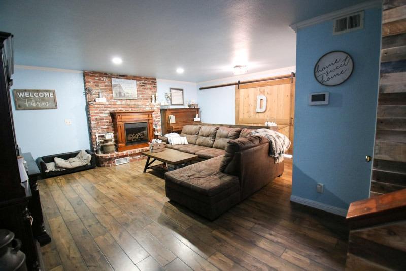 8053 South Rio Avenue Reedley, CA 93654 - Photo 5 of 30 a living room with furniture a clock on wall and a fireplace