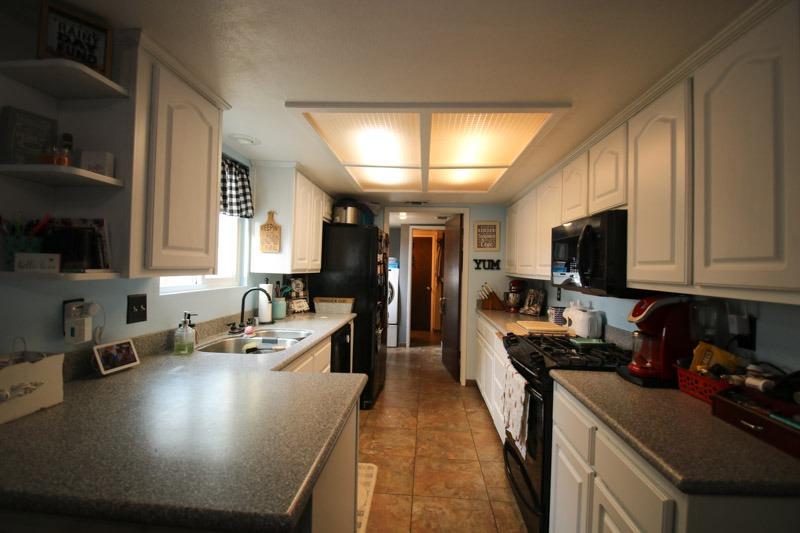 8053 South Rio Avenue Reedley, CA 93654 - Photo 8 of 30 a kitchen with kitchen island granite countertop a sink appliances cabinets and a counter top space