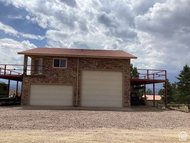 3 Red Circle, Unit 19 Manila, UT 84046 - Photo 3 of 29 View of side of home featuring stone siding, driveway, and a deck