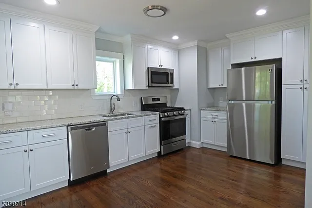 a kitchen with a refrigerator stove top oven and sink