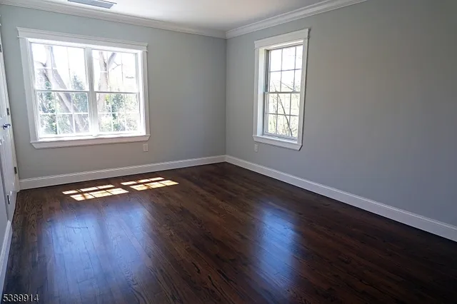 a view of room with wooden floor and windows