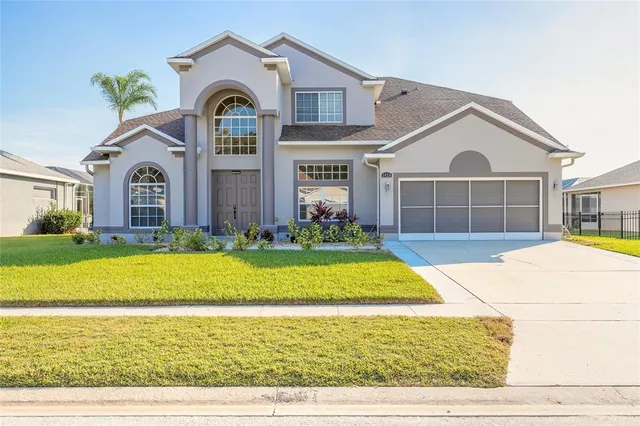a front view of a house with a yard and potted plants
