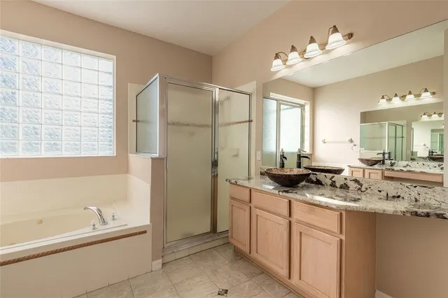 a view of an empty room with wooden floor and a ceiling fan