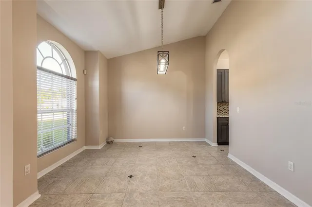 a view of a large pool with a lawn chairs and floor to ceiling window