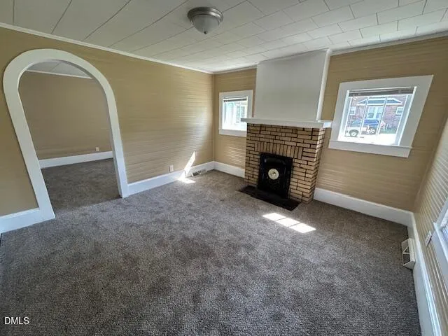 an empty room with fireplace and windows