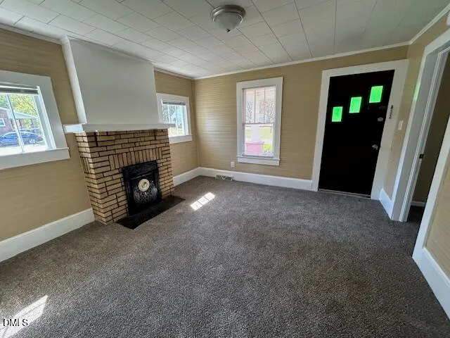 an empty room with windows and fireplace
