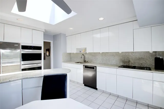 a kitchen with stainless steel appliances granite countertop a sink and a stove