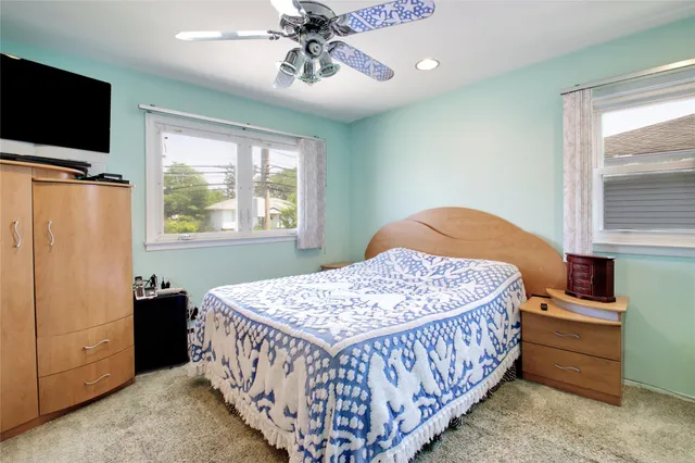 a bedroom with a bed and a flat tv screen on dresser