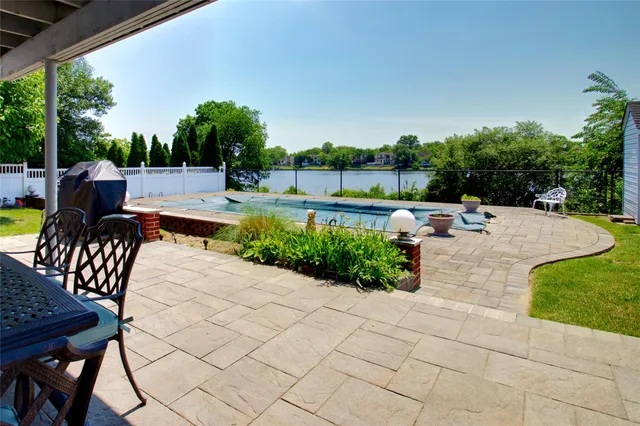 a view of a patio with dining table and chairs with a yard