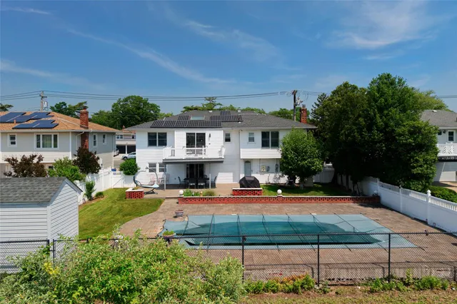 an aerial view of a houses with a yard and lake view
