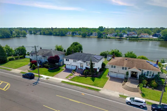 an aerial view of a house with outdoor space and lake view in back