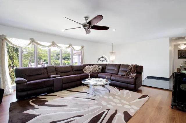 a living room with furniture wooden floor and a window