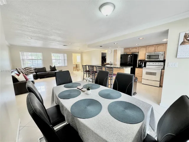 a kitchen with kitchen island a appliances dining table and chairs