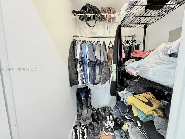 a view of walk in closet with clothes and shoes