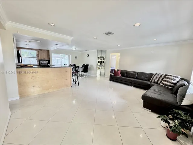 a living room with furniture and kitchen view