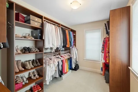 a view of walk in closet with clothes and shoes
