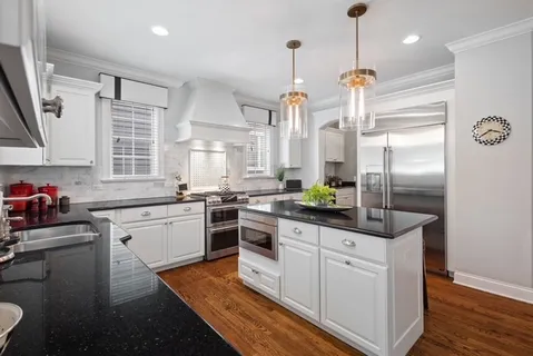 a kitchen with white cabinets and stainless steel appliances