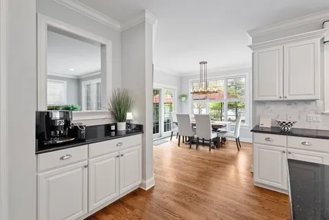 a kitchen with white cabinets and sink
