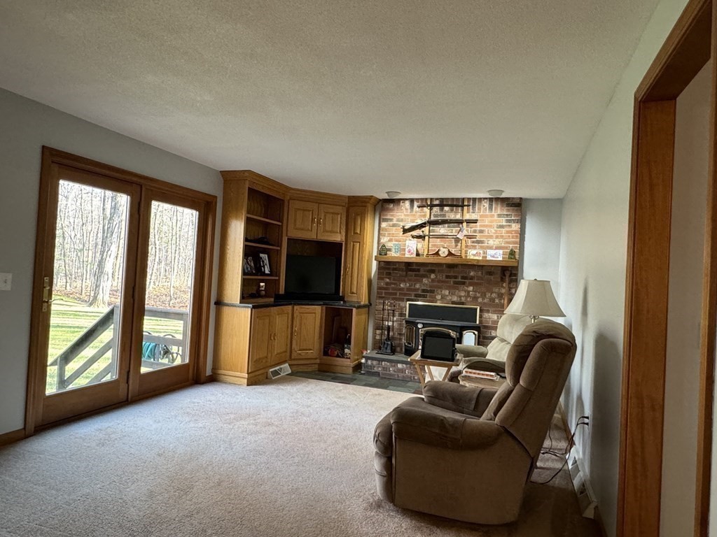 400 N Road Westfield, MA 01085 - Photo 12 of 27 a living room with furniture a flat screen tv and a fireplace