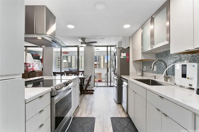 a kitchen with white cabinets sink and stainless steel appliances