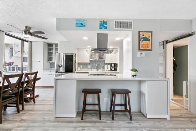 a kitchen with stainless steel appliances granite countertop a table and chairs in it