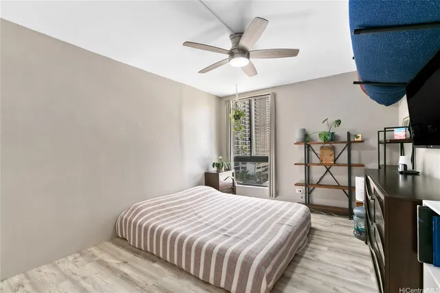 a bedroom with a bed table closet and flat screen tv