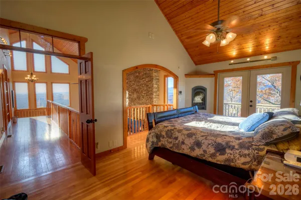 a bed sitting in a spacious bedroom next to a window