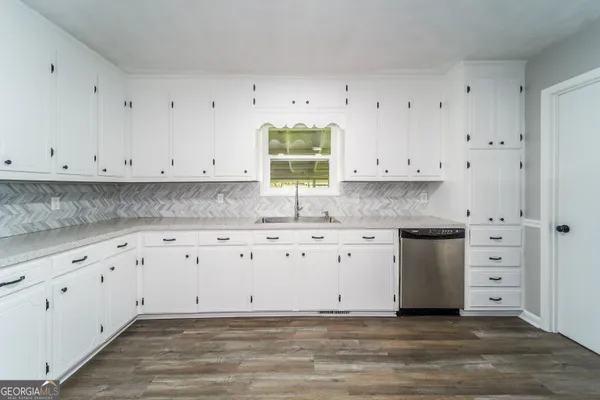 a kitchen with granite countertop white cabinets and a stove with granite countertop