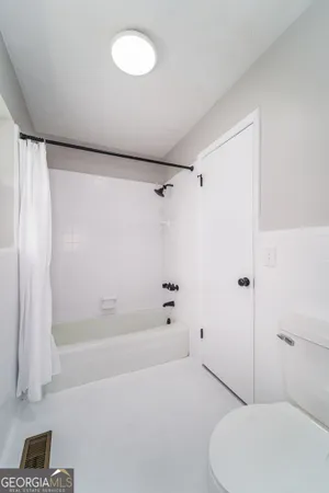 a bathroom with a toilet and a shower