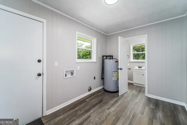 a view of a room with a fridge and wooden floor