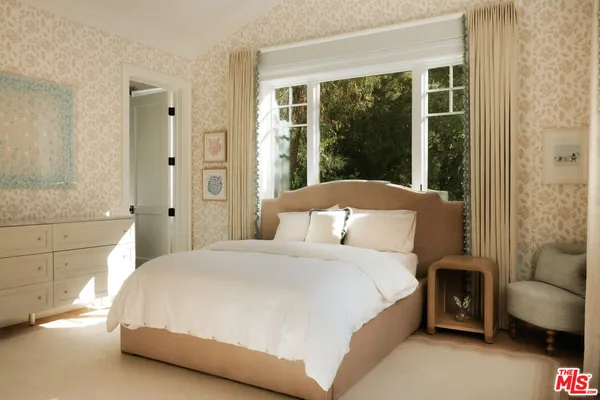 a bedroom with a bed and a couch next to a window