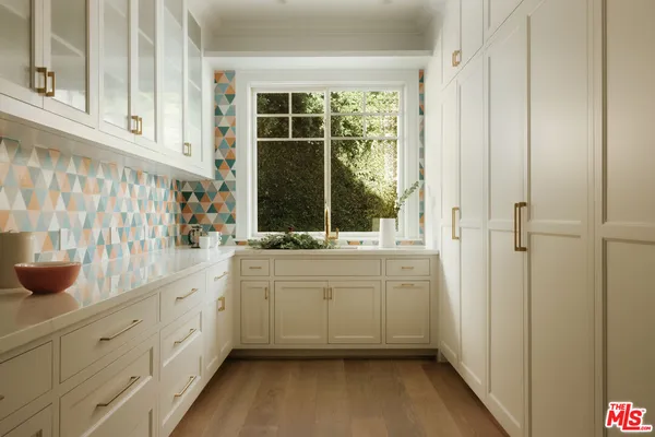 a bathroom with a sink and mirror with bathtub