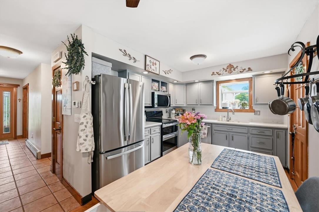 7722 Sechler Road New Tripoli, PA 18066 - Photo 13 of 58 Hardwood floors and matching cabinets anchor this functional cooking space with stainless steel appliances.