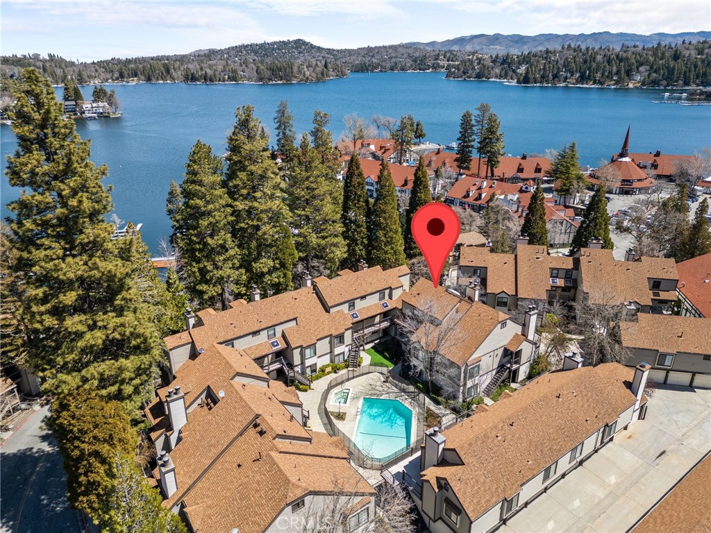 an aerial view of a house with swimming pool and lake view