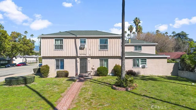a view of a house with backyard and sitting area