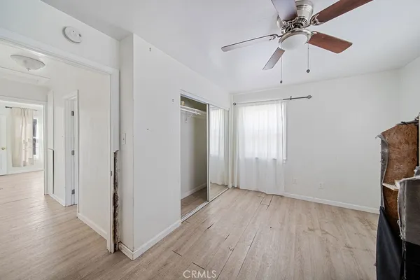 a view of a room with wooden floor fan and windows