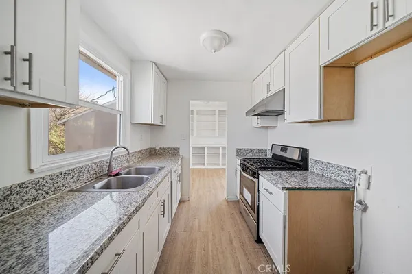 a kitchen with stainless steel appliances granite countertop a sink stove and cabinets