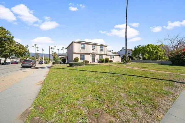 a view of a city street lined with buildings and cars parked