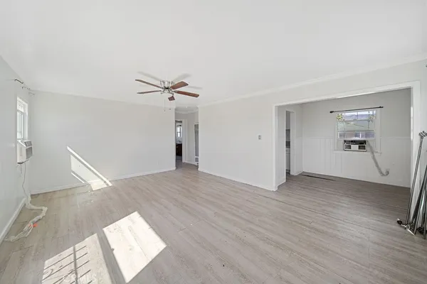 a view of a livingroom with wooden floor and a ceiling fan