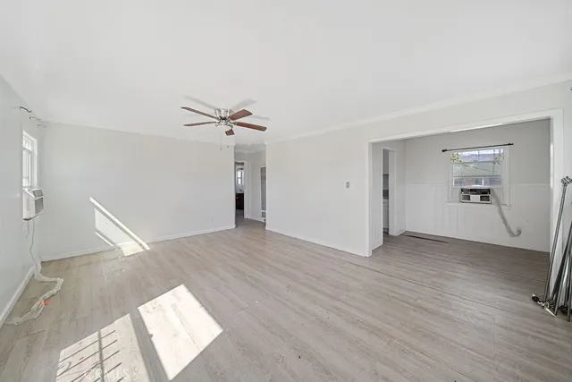 a view of a livingroom with wooden floor and a ceiling fan