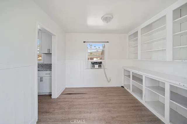a view of empty room with wooden floor and cabinet