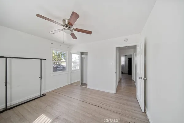 a view of a livingroom with a chandelier fan and windows