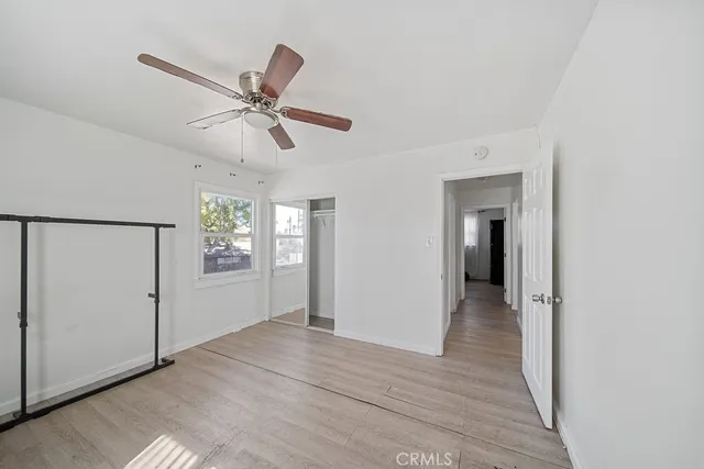 a view of a livingroom with a chandelier fan and windows