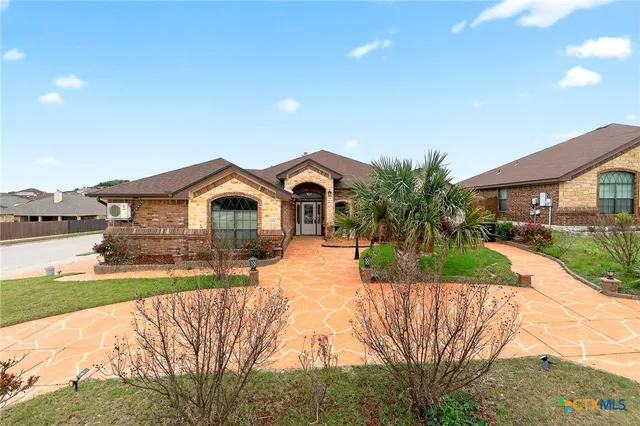 a front view of a house with a yard and potted plants