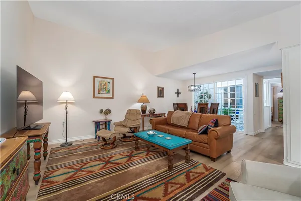 a living room with furniture a flat screen tv and a window